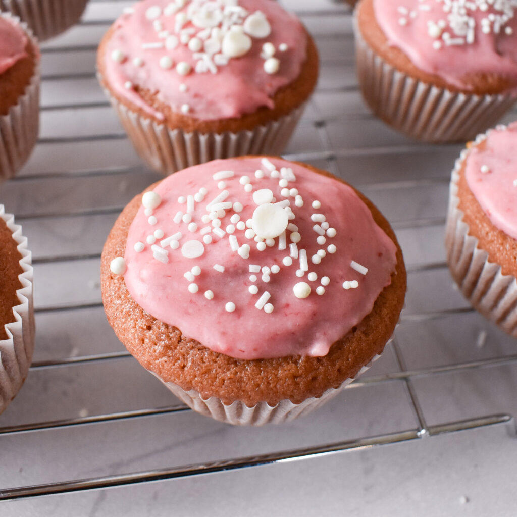 Strawberry cupcakes on cooling rack.
