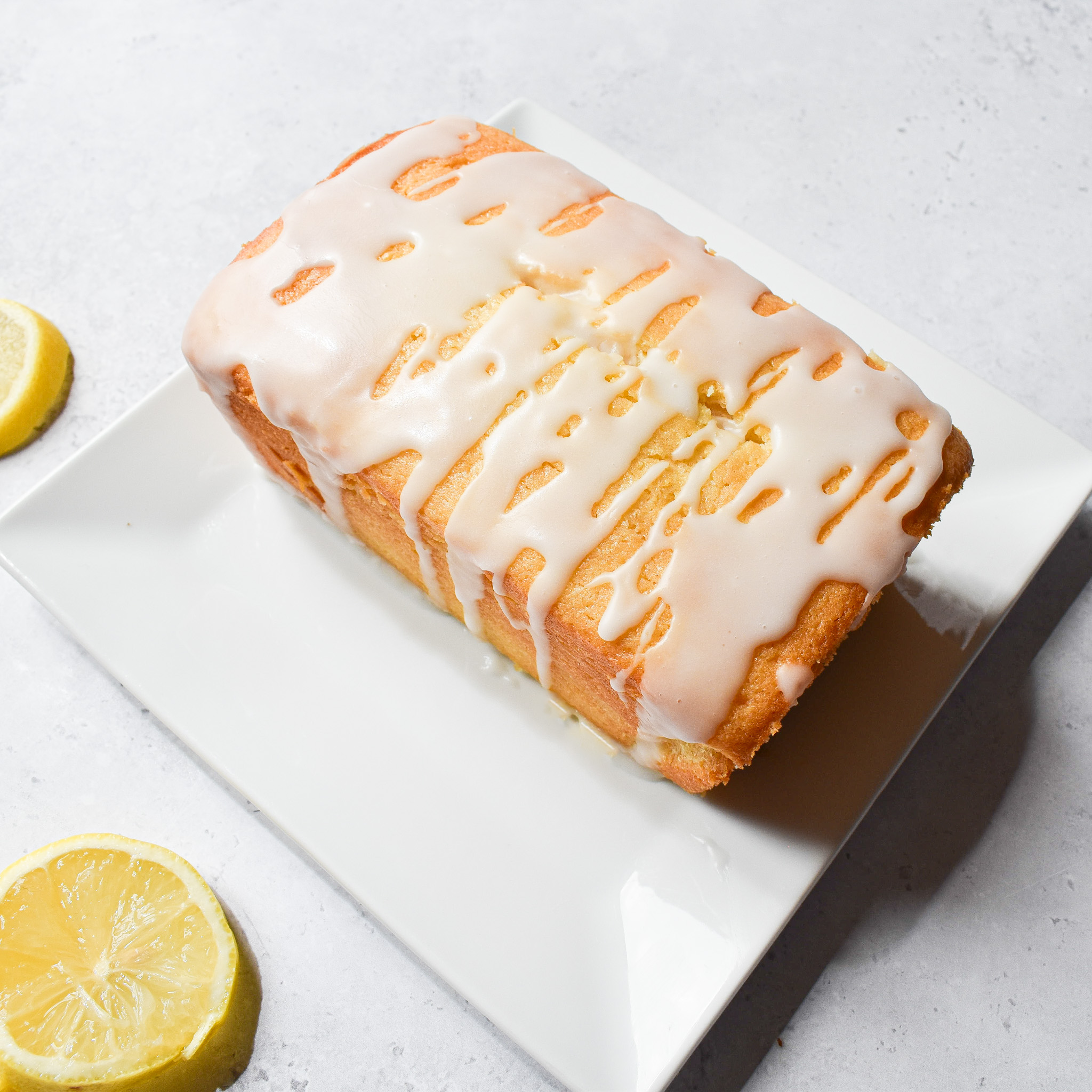 Lemon drizzle 1lb tin loaf cake on plate.