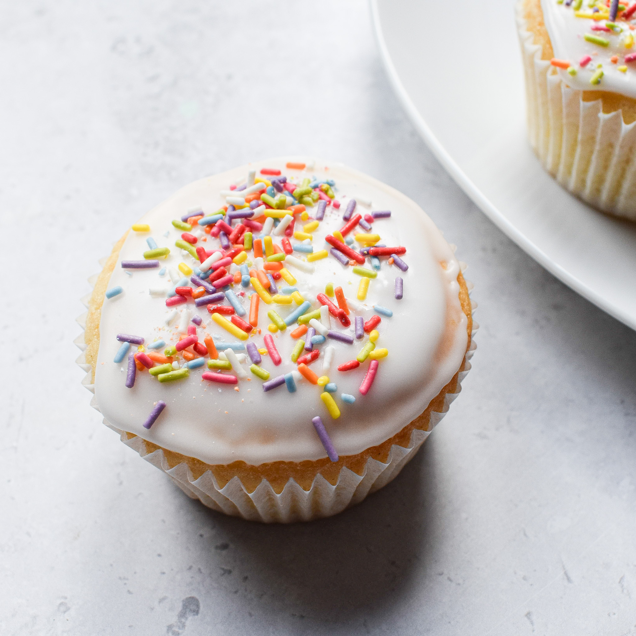 A single fairy cake on white surface.