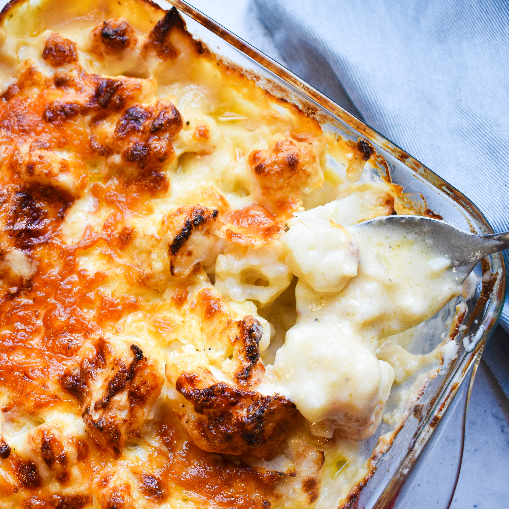Creamy cauliflower cheese cut to expose the cheese sauce inside.