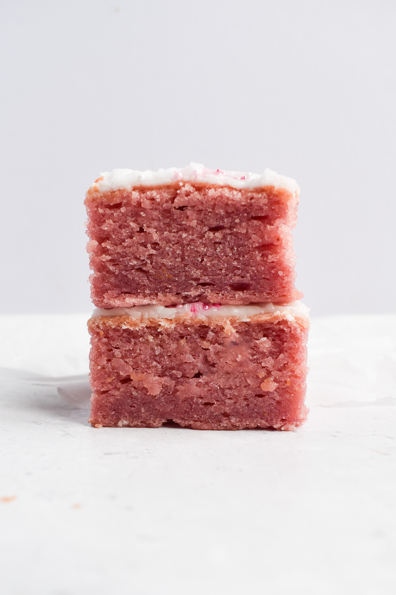 2 raspberry cake squares stacked.
