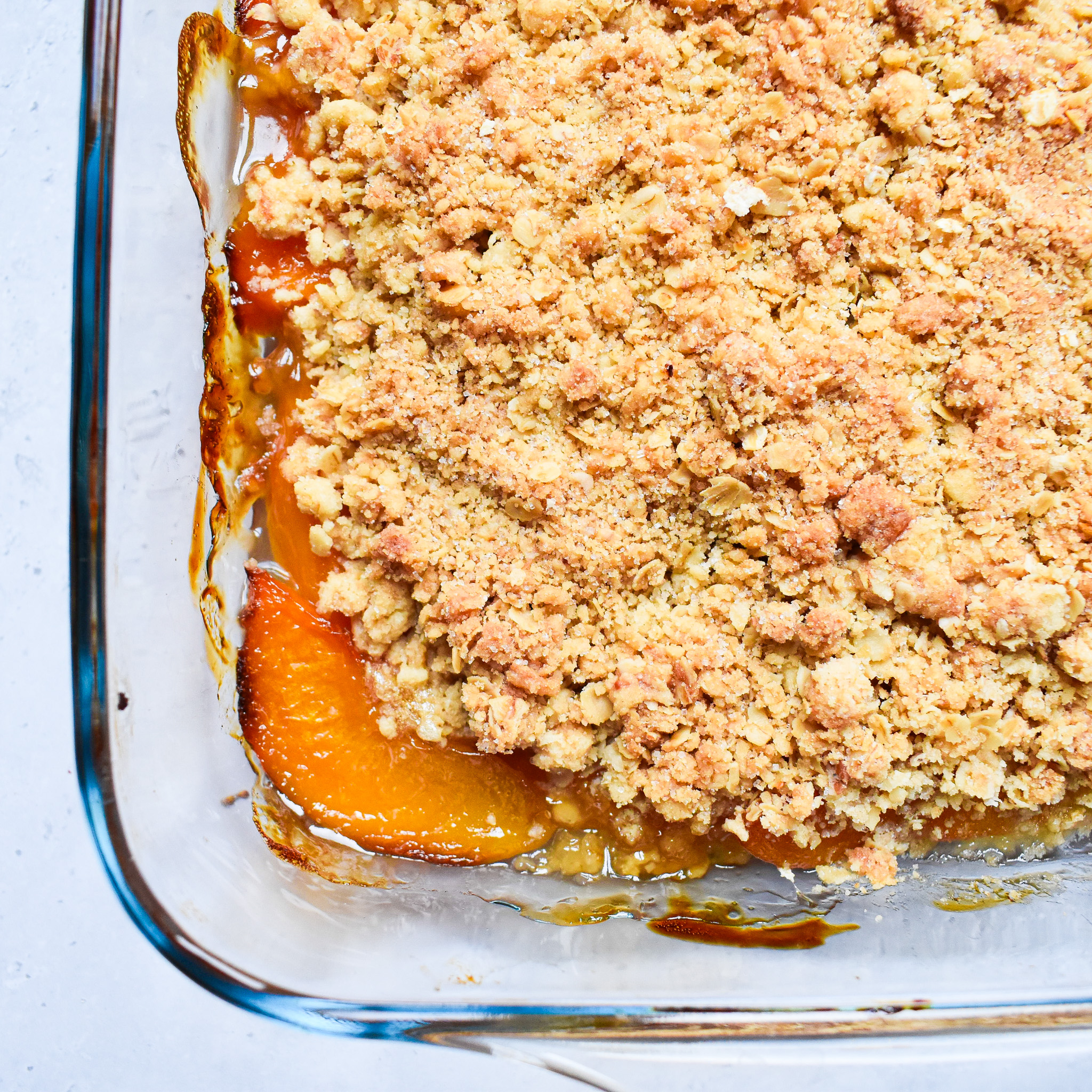peach crumble in clear baking dish.