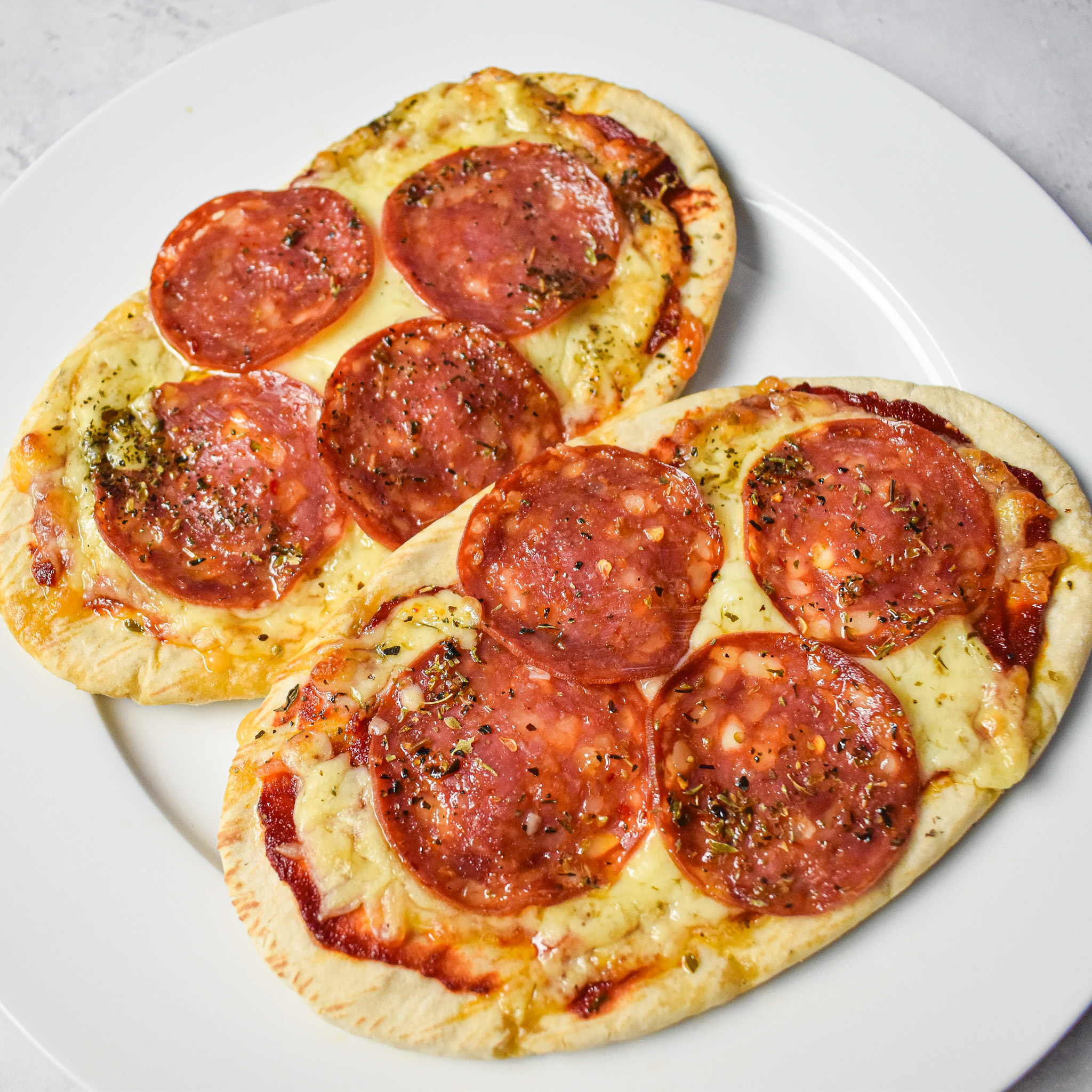 Pitta pizzas on a white plate.