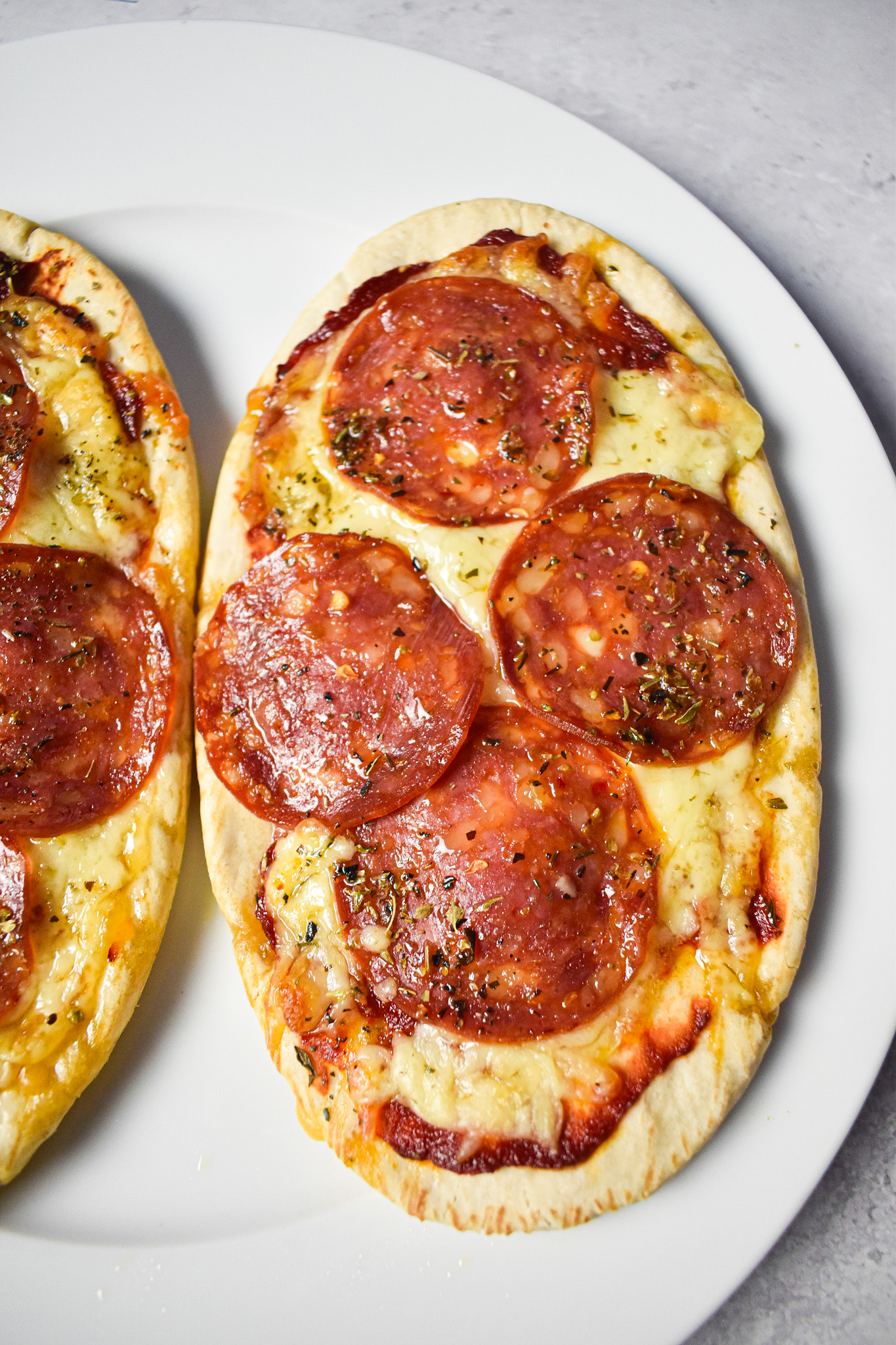 pepperoni pitta pizza on a white plate.