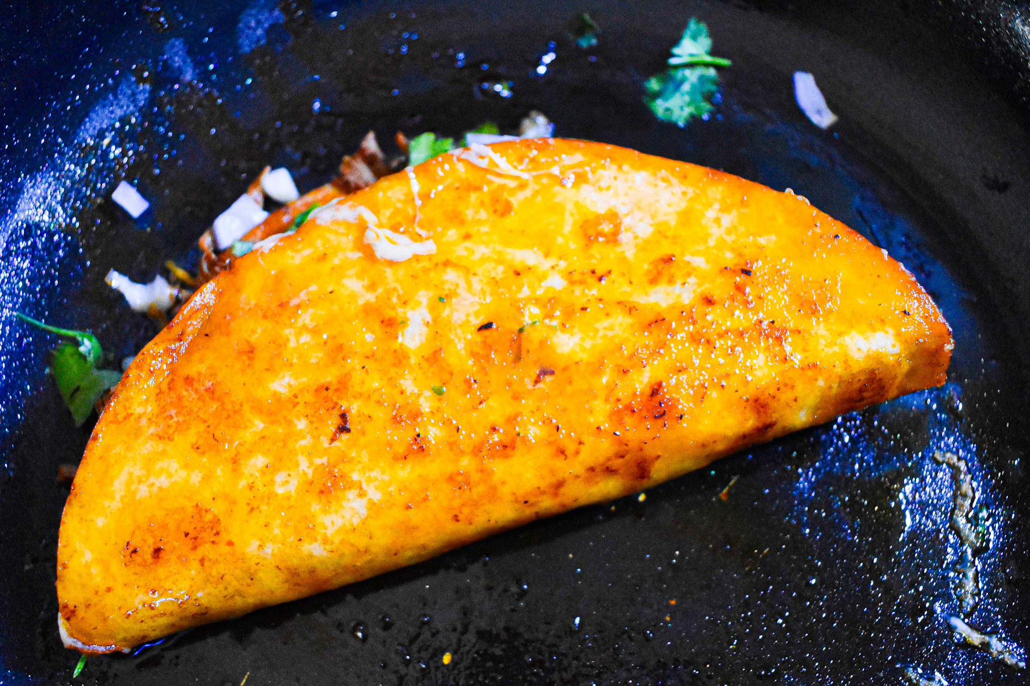 assembled birria taco in a pan.